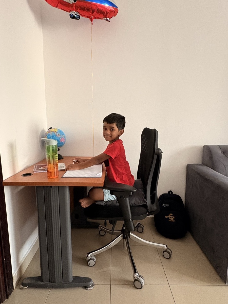 Dhyanchand sitting at his study desk looking curious and happy